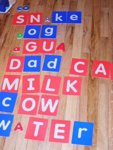 Children's letter cards spelling words on wood floor