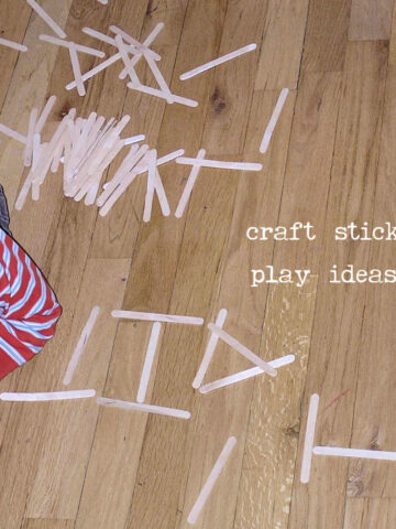 child forming letters with craft sticks