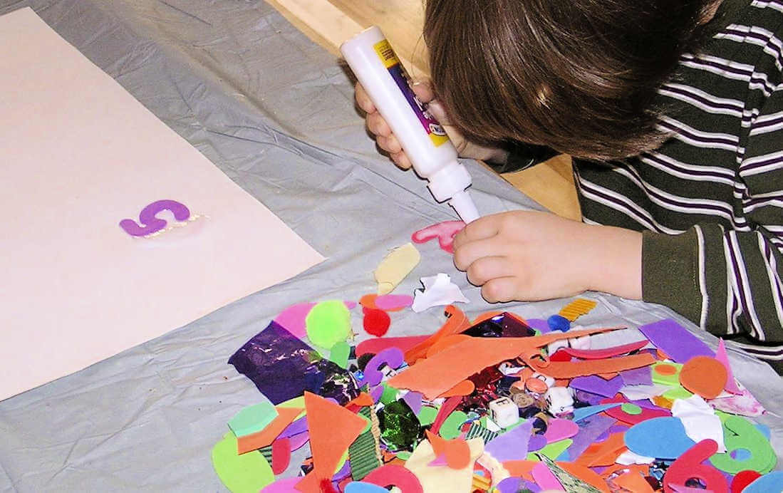 Putting glue on numbers collage art materials