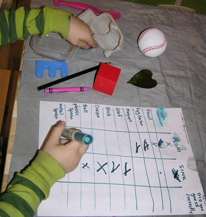 Float or sink experiment with child filling in worksheet