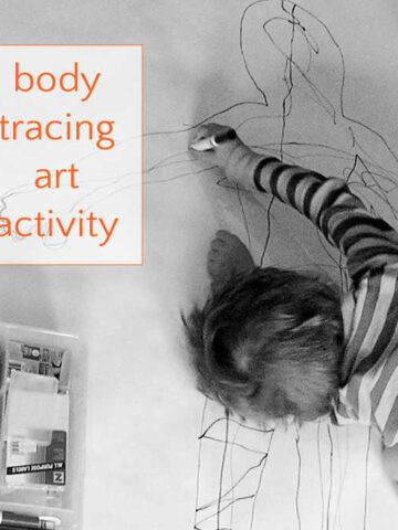 child drawing on large piece of paper with body outline