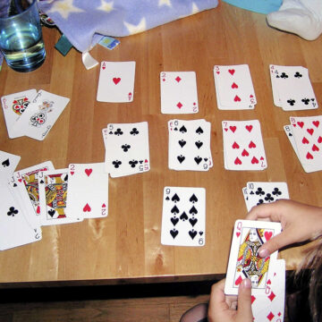 Child sorting playing cards by suit