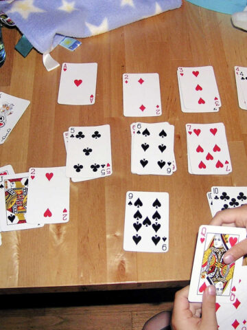 Child sorting playing cards by suit