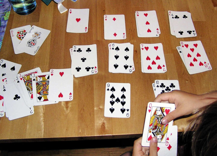 Child sorting playing cards by number