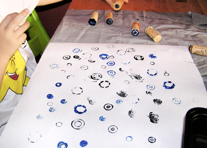 Child making art with button stamps