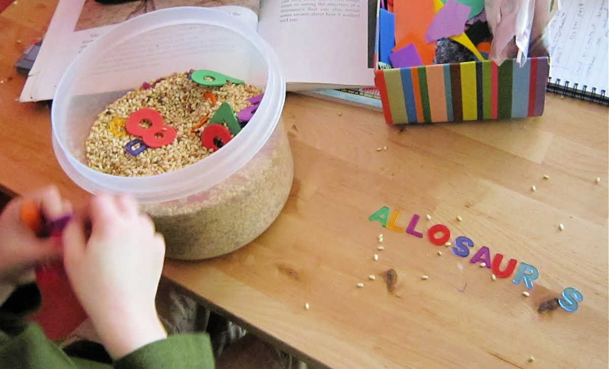 Child looking for letters in alphabet sensory bin