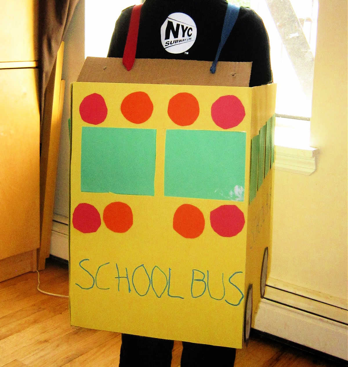 Back view of Child wearing school bus costume made from cardboard box