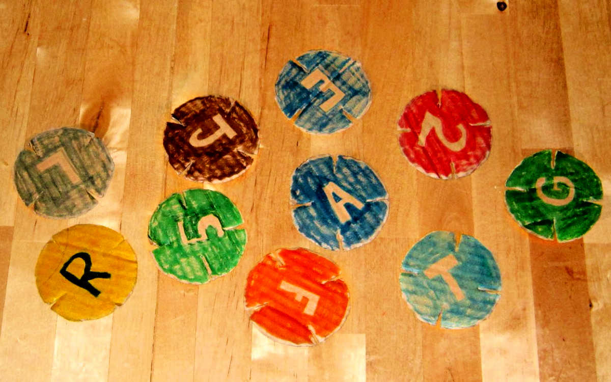 Notched cardboard discs with colored train symbols draw on them.