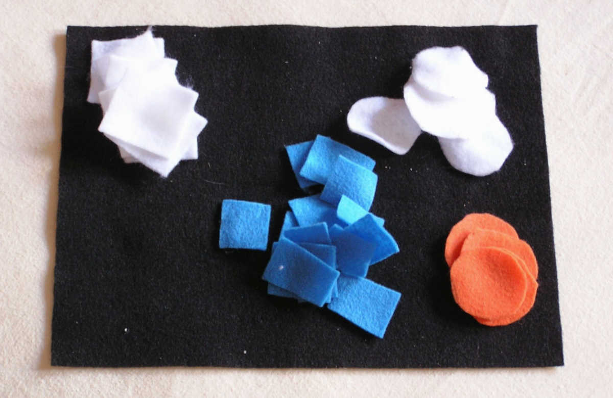 Piles of white square, white circle blue square, orange circle felt shapes on black background.