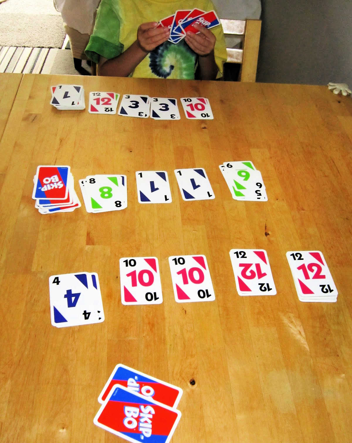 Child at table with Skip-bo cards
