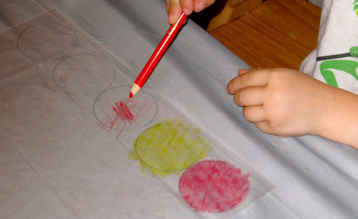 Child coloring circles on shrink plastic sheets
