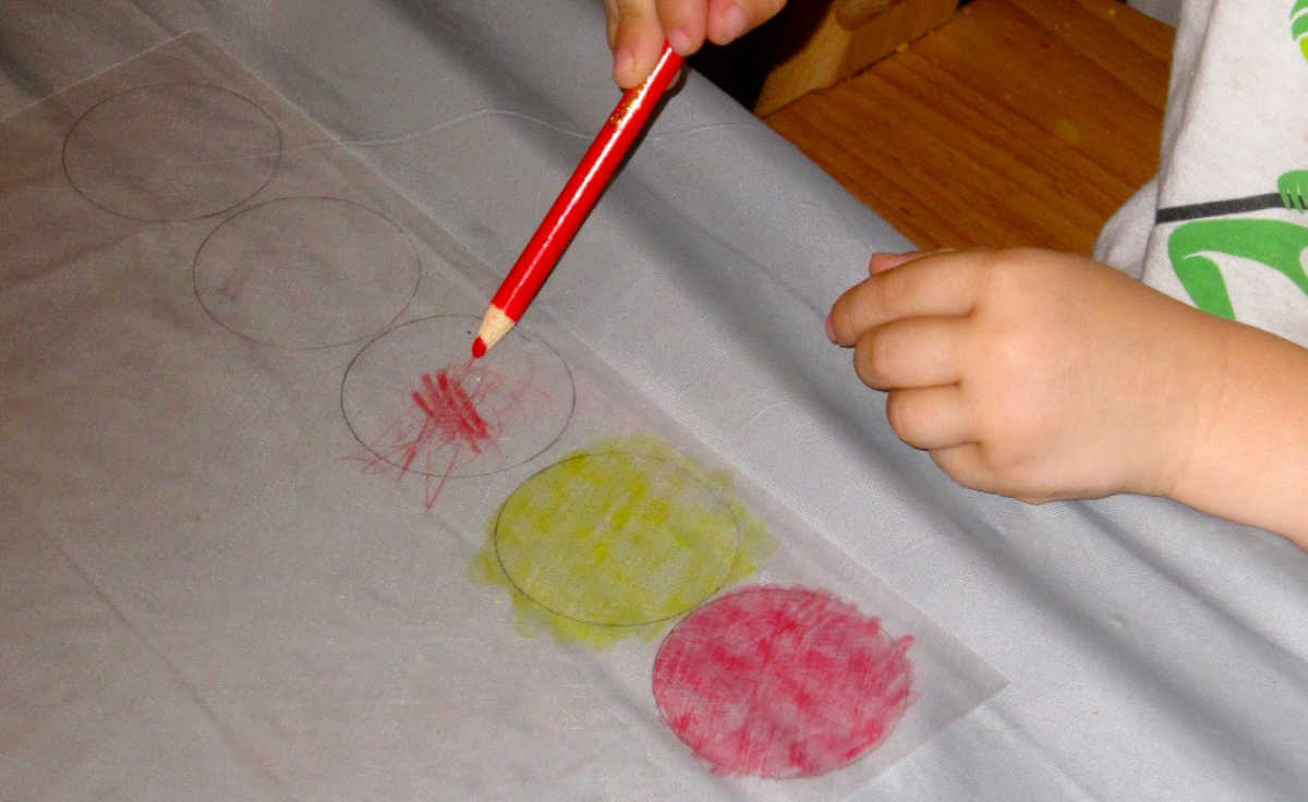 Child coloring circles on shrink plastic sheets