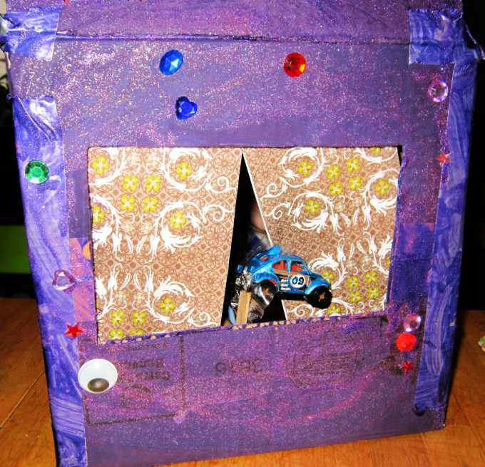 Close up of finished cardboard box puppet theater with car on a stick as a puppet