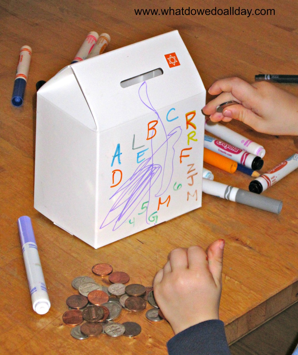child decorating tzedakah box