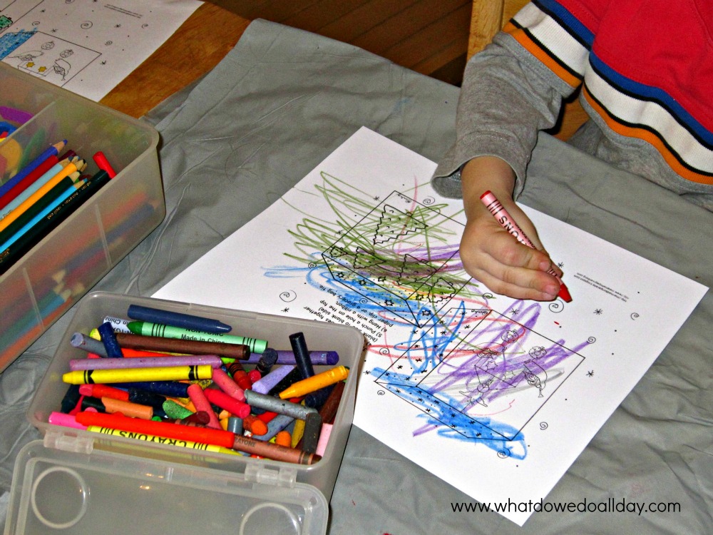 christmas ornament coloring page Child's hand scribbling with crayons on coloring page next to open boxes of crayons and colored pencils.
