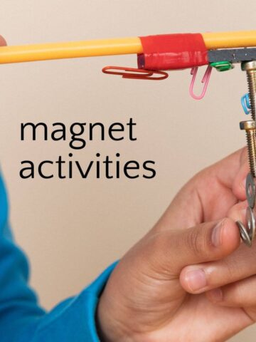 Child playing with magnet wand and paperclips