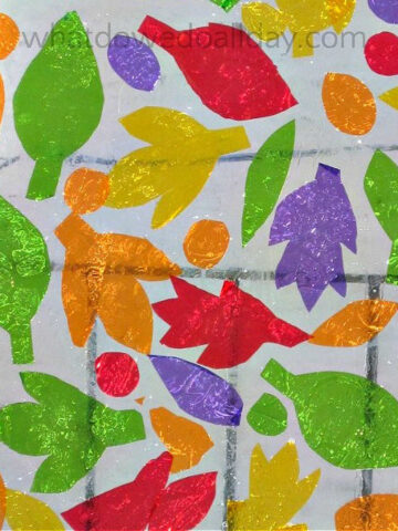 Colorful cellophane cut into leaves and dots and applied on a window.