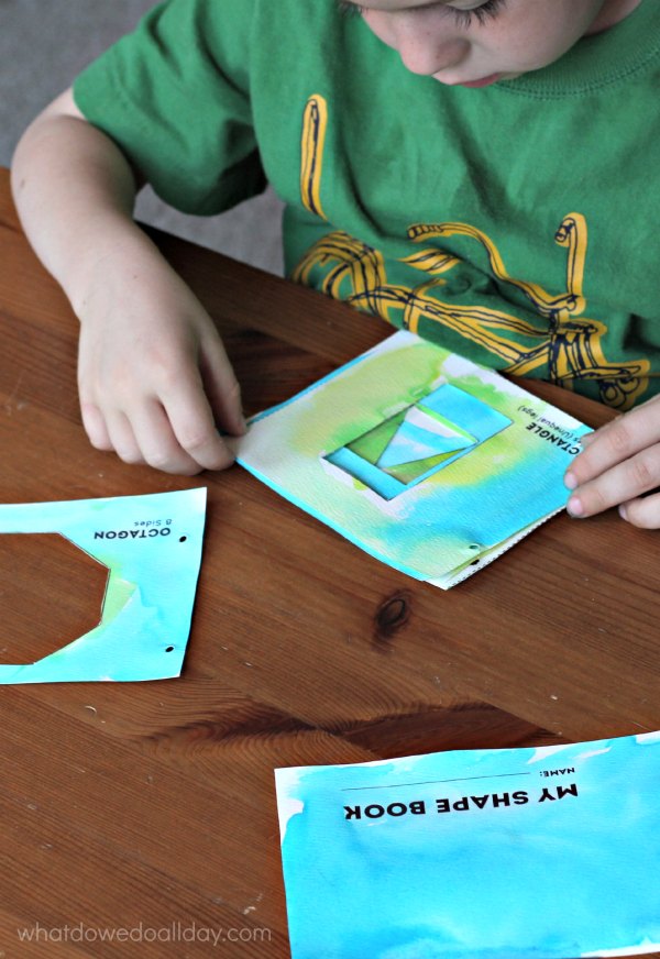Child putting together pages of shape book.