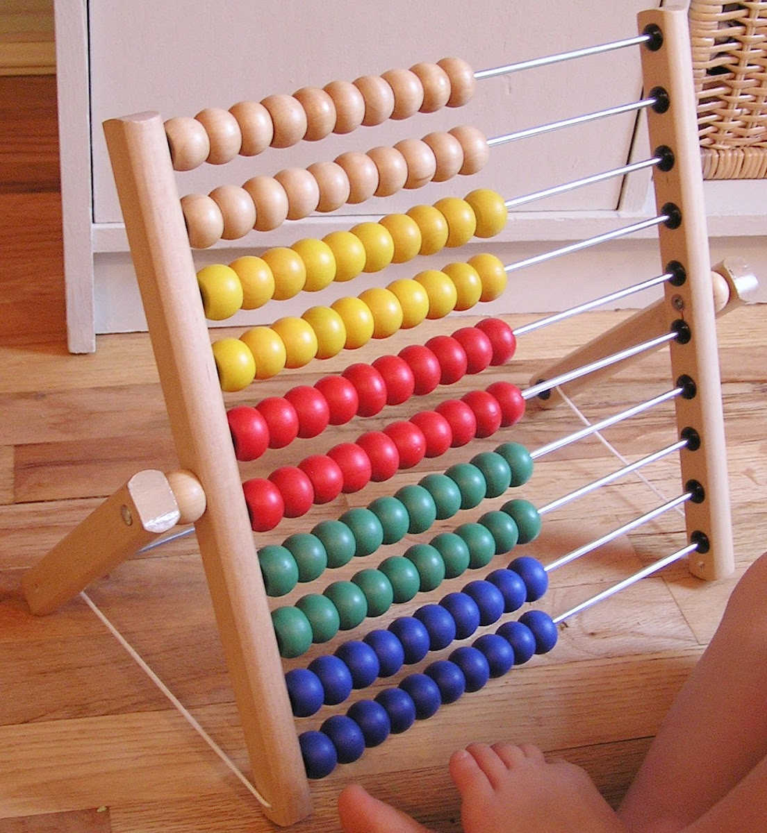 Large toy abacus with rows of large wooden, colored beads.