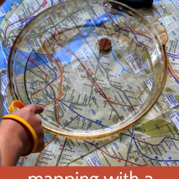 Hand pointing to homemade cork compass in dish of water on a map.