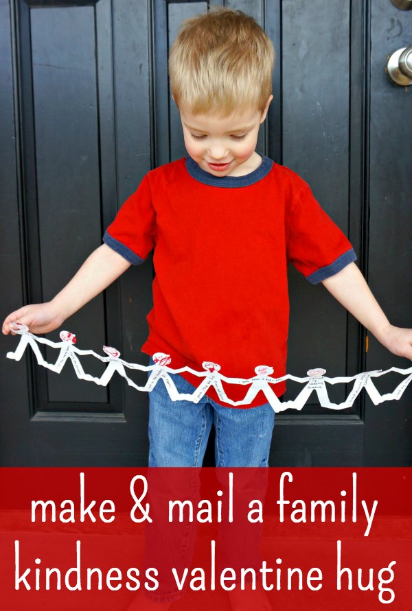 Boy in red shirt holding giant hug made from paper doll chain