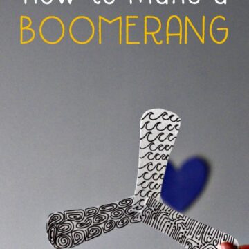Hand holding paper indoor boomerang in shape of star with three arms.