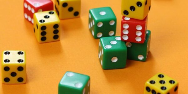 Collection of colored dice on orange background.