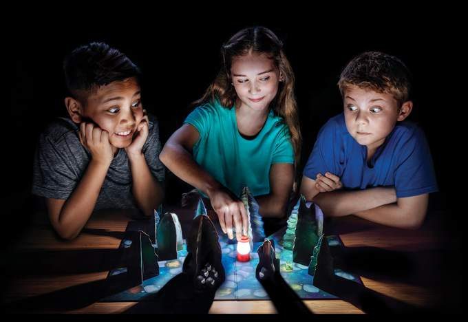 Three kids playing Shadows in the Forest game