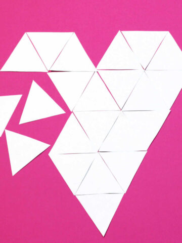Geometry puzzle in the shape of a heart made from triangles, with several of the triangles that form the puzzle loose off to the side.