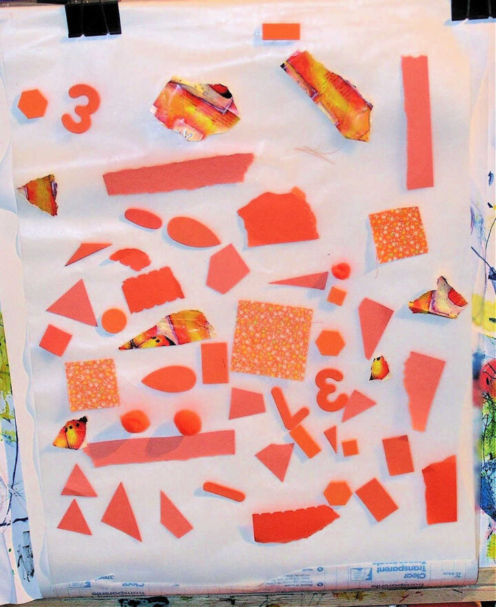 Child made collage on sticky paper with orange craft items