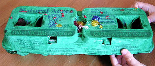 closed egg carton painted green with sparkles