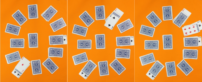 Playing cards set out in a circle formation three times. 