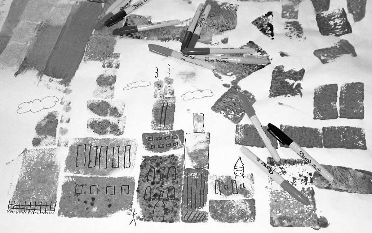 Black and white photo of children's art project of a skyline created by sponge painting shapes.