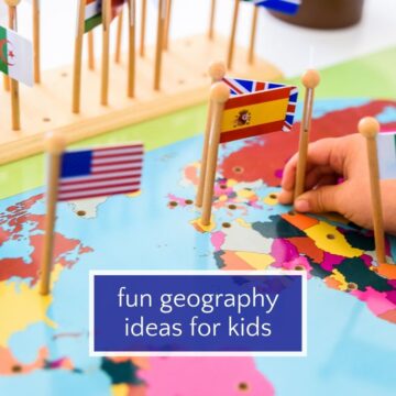 Child's hand placing small flags into a map of the world.