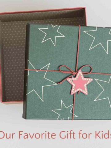 Open green gift box with pink star tag and ribbon.