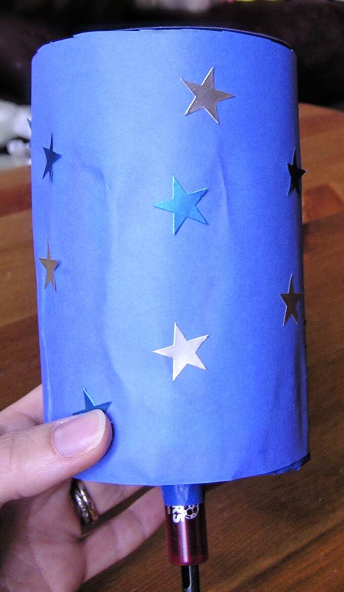 blue paper with star stickers wrapped around tube to make a moon phase viewer