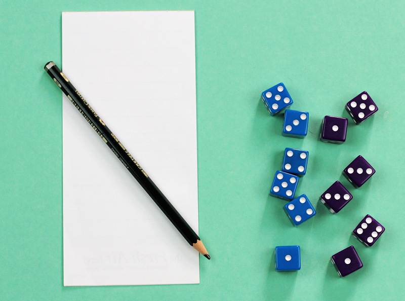 Pencil and paper with six blue dice and six purple dice on aqua background
