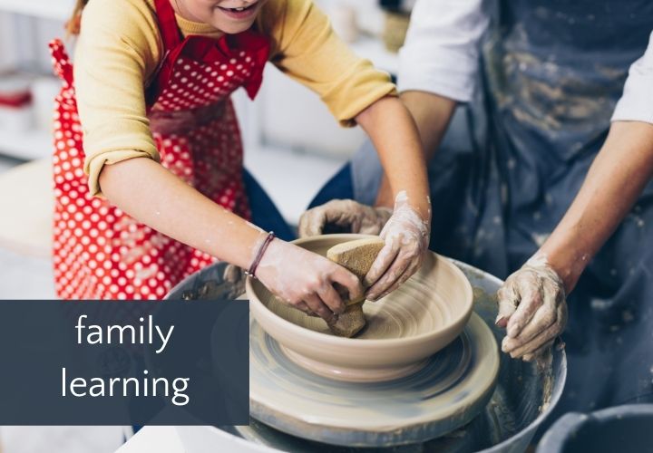 Child and adult making pottery on pottery wheel