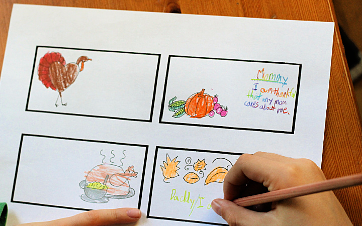 Child's hands coloring Thanksgiving place cards with colored pencil