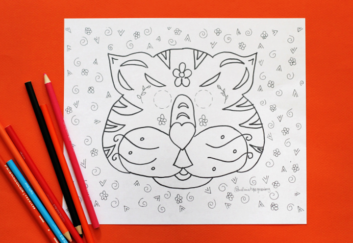Printable tiger mask coloring page on orange background