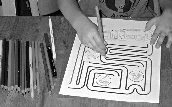 Child completing train maze coloring page