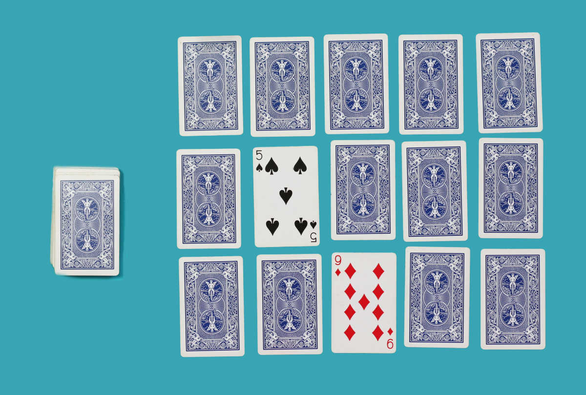 Playing cards laid out for turn over 10 math memory card game, showing 9 and 5 cards face up. 