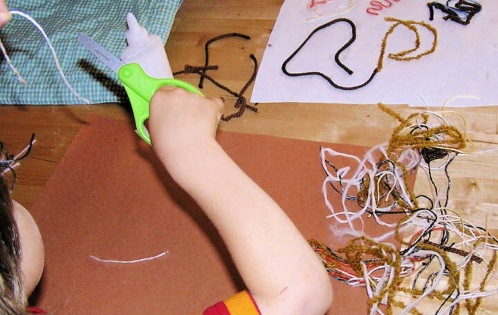 Child cutting string in different pieces