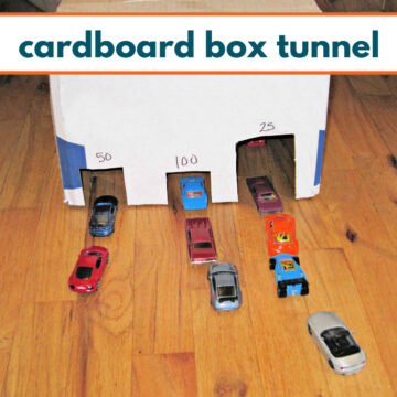 Three entrance tunnel made out of a cardboard box with lines of toy cars waiting to go through.