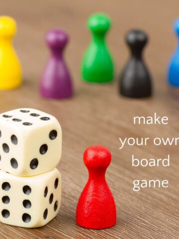 Game pieces and dice on table surface with text, make your own board game