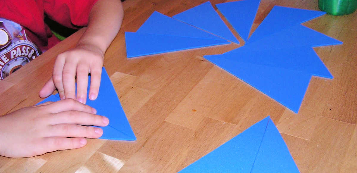 Child playing with blue Montessori triangles
