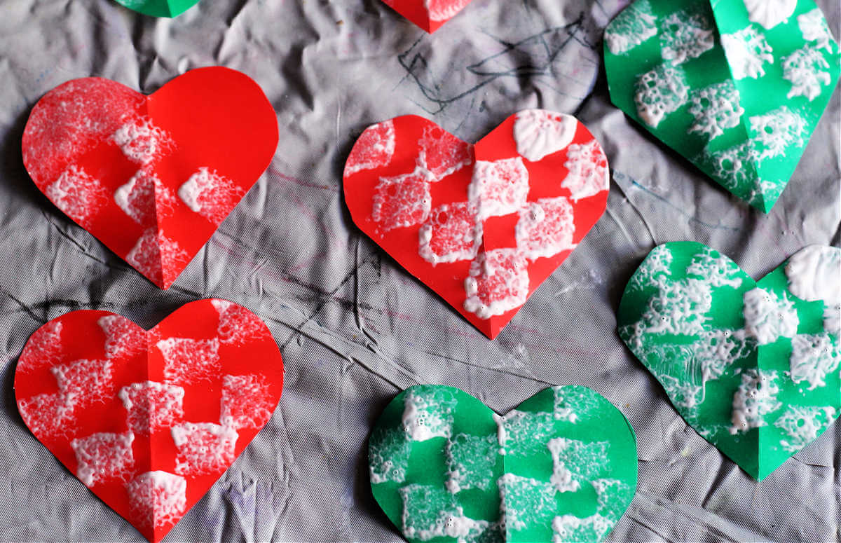 Array of finished sponge-painted paper heart ornaments. 