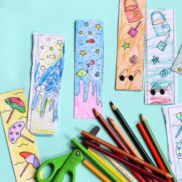 Colored summer reading bookmarks alongside kids scissors and coloring pencils.