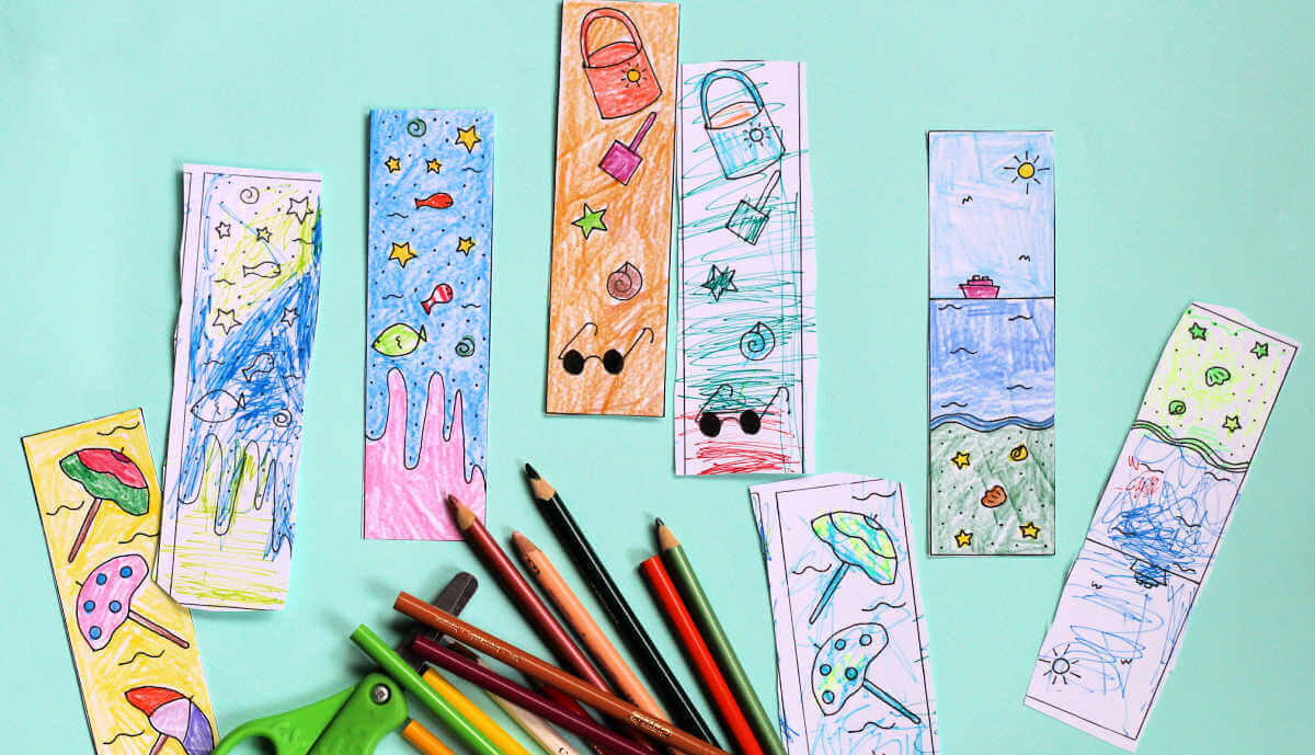 Colored summer reading bookmarks alongside kids scissors and coloring pencils.