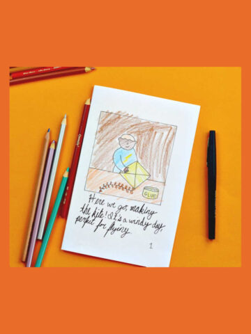 Finished cover of child-made kite storybook using coloring page, plus coloring pencils on the side.